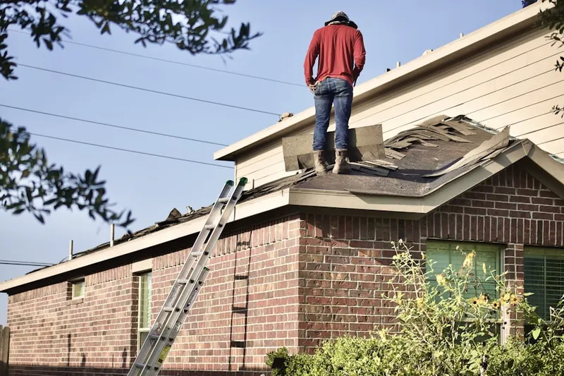 Professional roofer working on a residential roof in Henson Farms